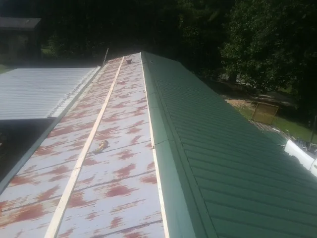 Old rusted panels beside newly installed green metal roofing — Wind Damage Roof Repair by Roofing Brothers in Old Hickory