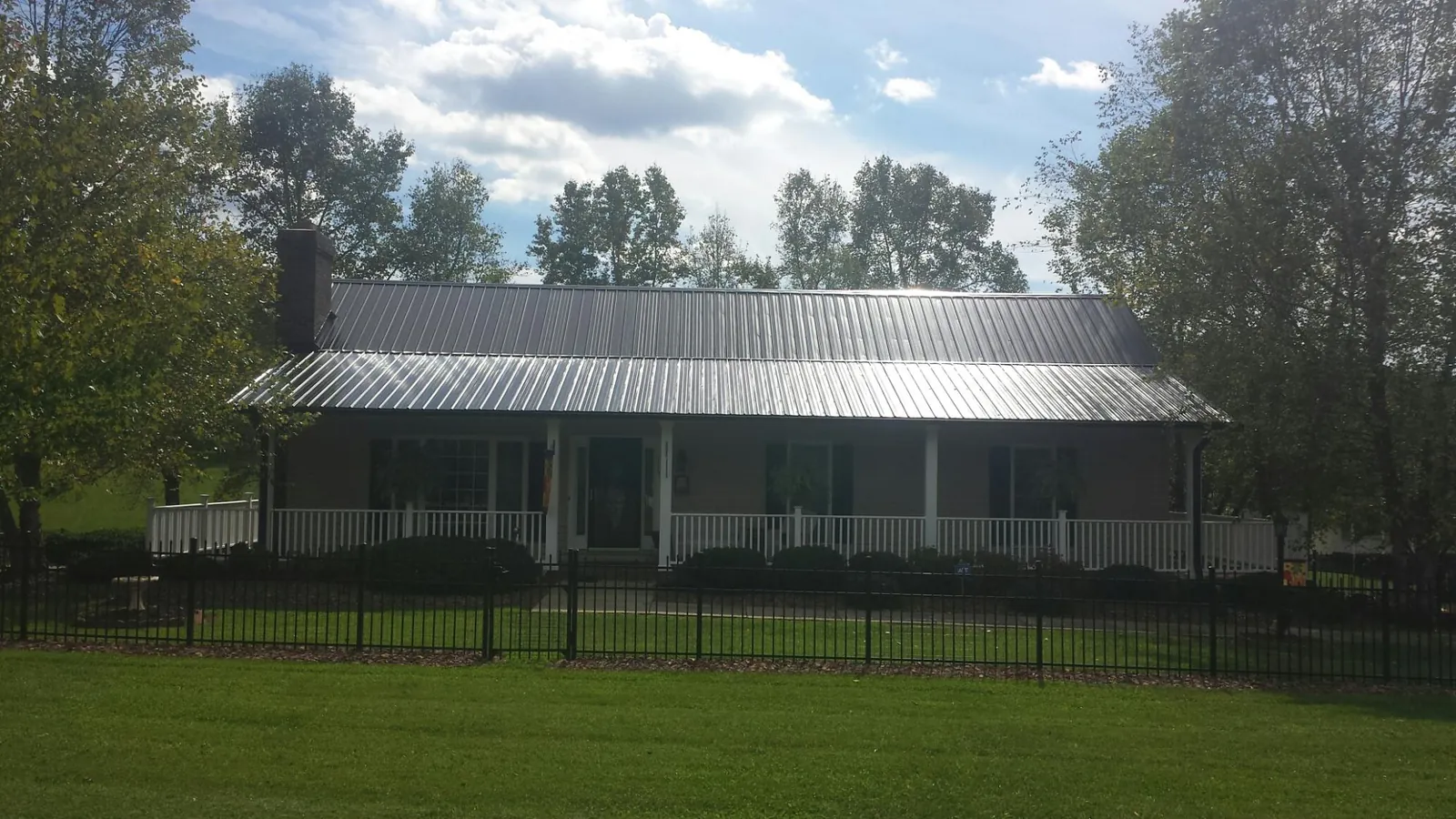 Gray metal roof on a brick ranch with a full width front porch — Gutter Guard Installation work by our crew in Old Hickory