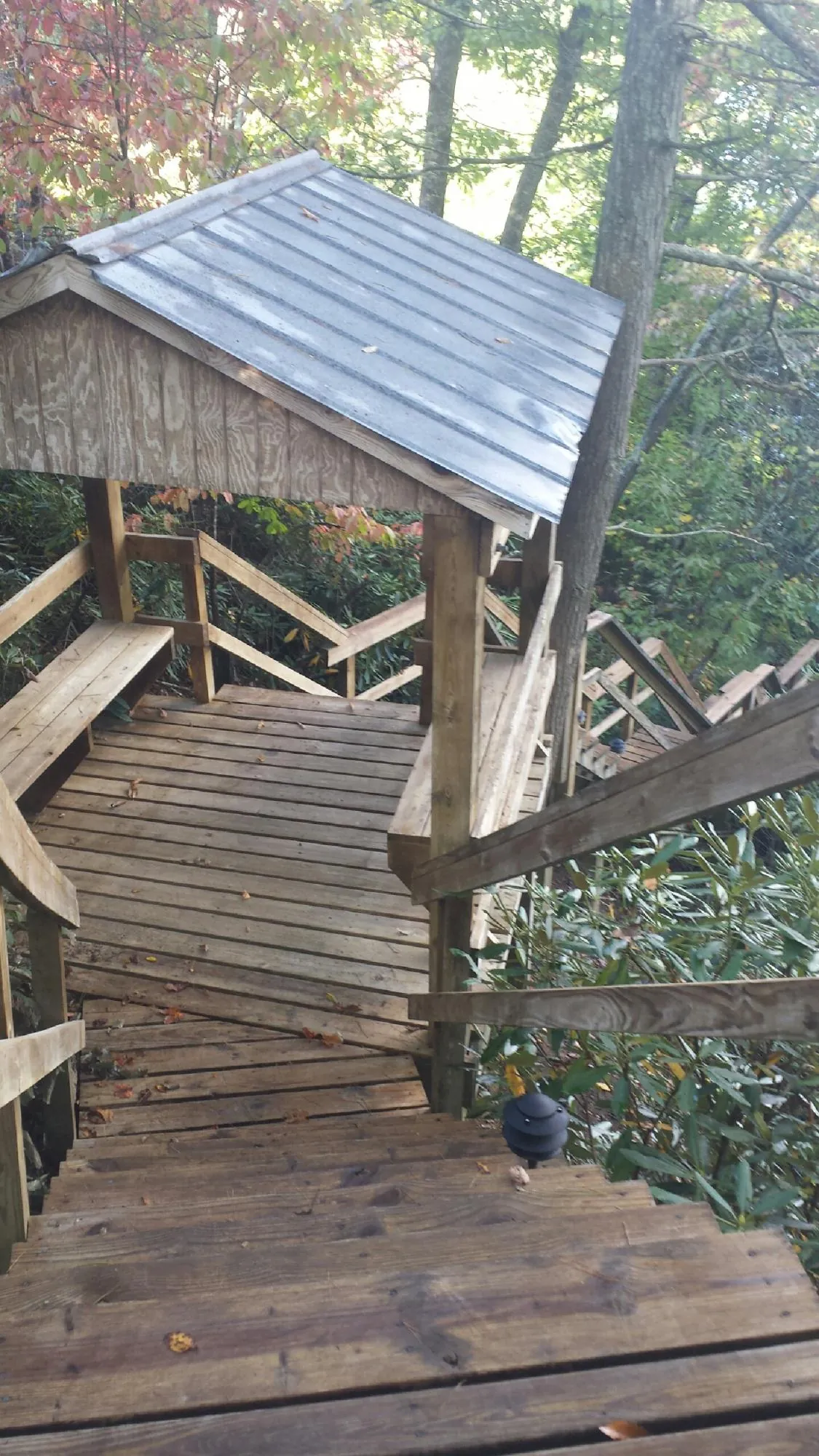 Metal roofed shelter over wooden steps on a wooded walkway — Skylight Repair & Installation work by our crew in Old Hickory